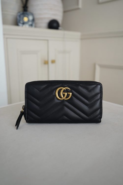Gucci GG Marmont Zip around Wallet featuring an antique gold-toned double G logo 